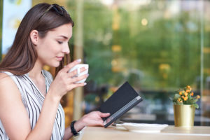 Woman relaxing with a book at a cafe