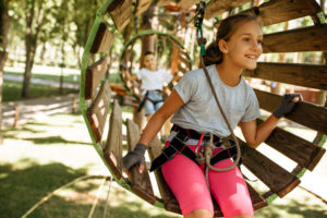Girl smiling on a wooden ropes course