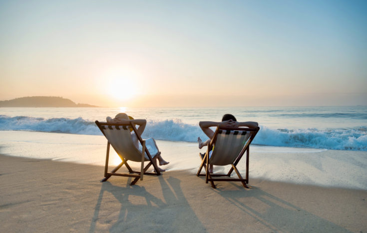 Couple,Sunbathing,On,A,Beach,Chair.