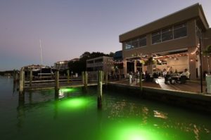 Exterior of Dry Dock Waterfront Grill glowing green in the evening