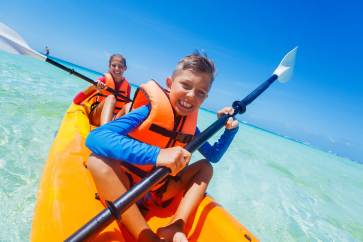 Kids,Enjoying,Paddling,In,Orange,Kayak,At,Tropical,Ocean,Water