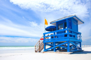Yellow warning flag on blue lifeguard stand in Siesta Key