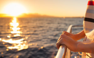 Woman holding side of a boat during a sunset cruise