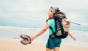 Girl backpacker traveler enjoys with fresh ocean wind