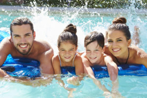 Family of four splashing in a pool