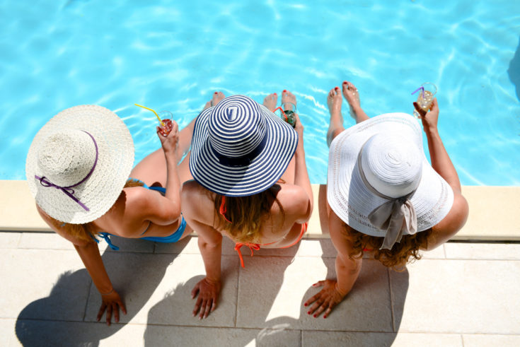 Three,Beautiful,Young,Woman,With,Sun,Hat,Sitting,By,The