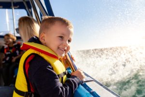 Little boy on a boat watching the water