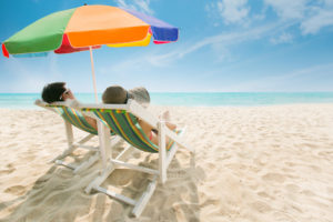 Couple sunbathing on a beach chair and umbrella color The beach is bright blue. During the summer