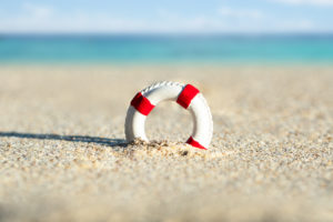 Close-up,Of,Miniature,Lifebuoy,Dig,In,The,Sand,At,Beach