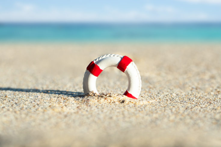 Close-up,Of,Miniature,Lifebuoy,Dig,In,The,Sand,At,Beach