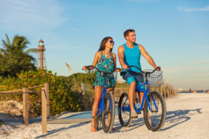 Couple riding bikes on the beach