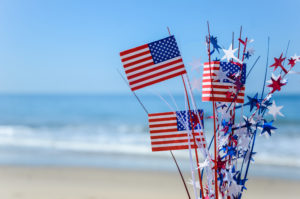 Patriotic USA background with flags and decorations on the sandy beach