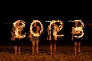 Happy New Year 2023.young friends having fun at New Year's Eve Party 2023 and Sparkling burning numbers Year 2023 at beach.people with firework outdoor enjoy emotions and feeling