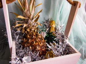 festive composition with pineapple and champagne in a decorative box