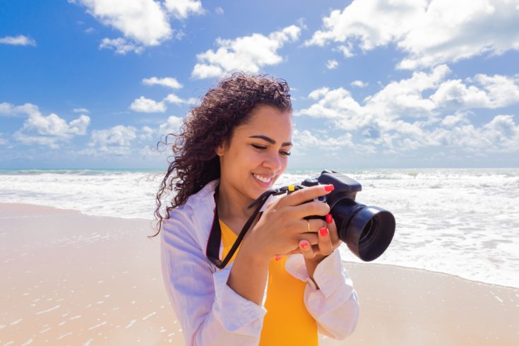 Woman,On,The,Beach,On,Vacation,Photographing,In,Summer.,Young