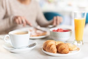 Coffee and croissant for breakfast in a table.