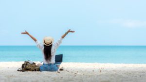 Lifestyle freelance woman using laptop working and relax on the beach.Â  Asian people success and together your work pastime and meeting conference on internet in holiday. Business and Summer Concept