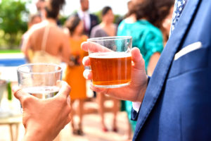 Unrecognizable people with drinks in their hands talk to each other about business at a networking event