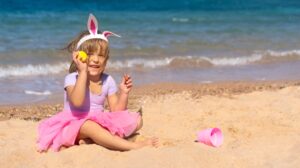 Child on beach with Easter egg